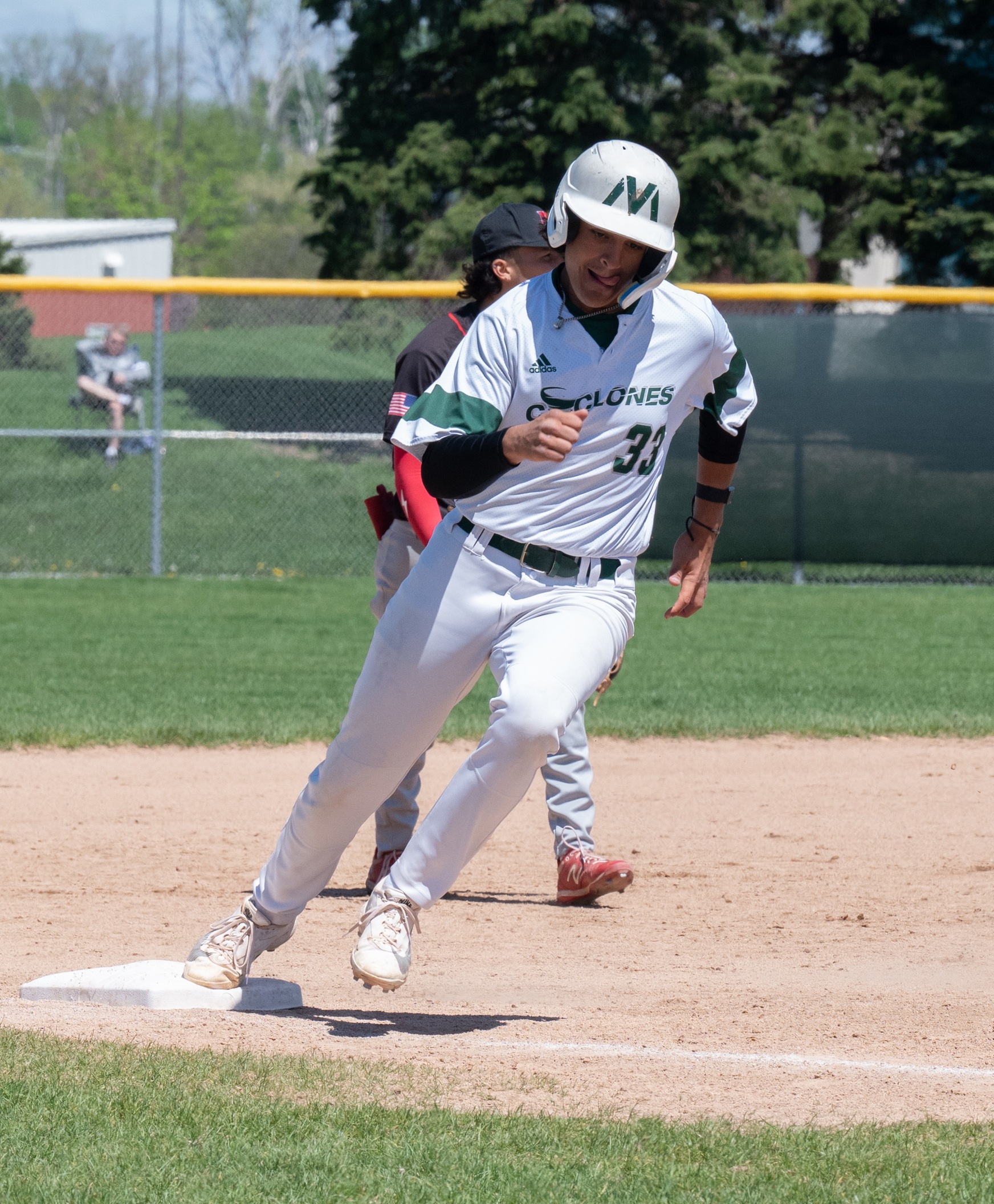 A Cyclone baseball player rounds third on his way to score.