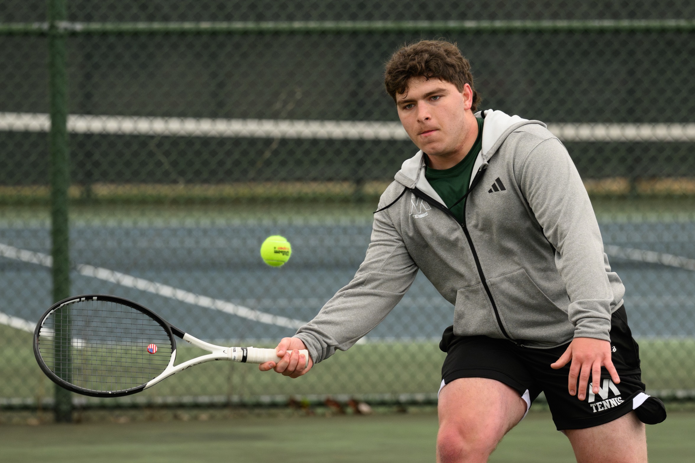 A Moraine Valley men's tennis player hits the ball.