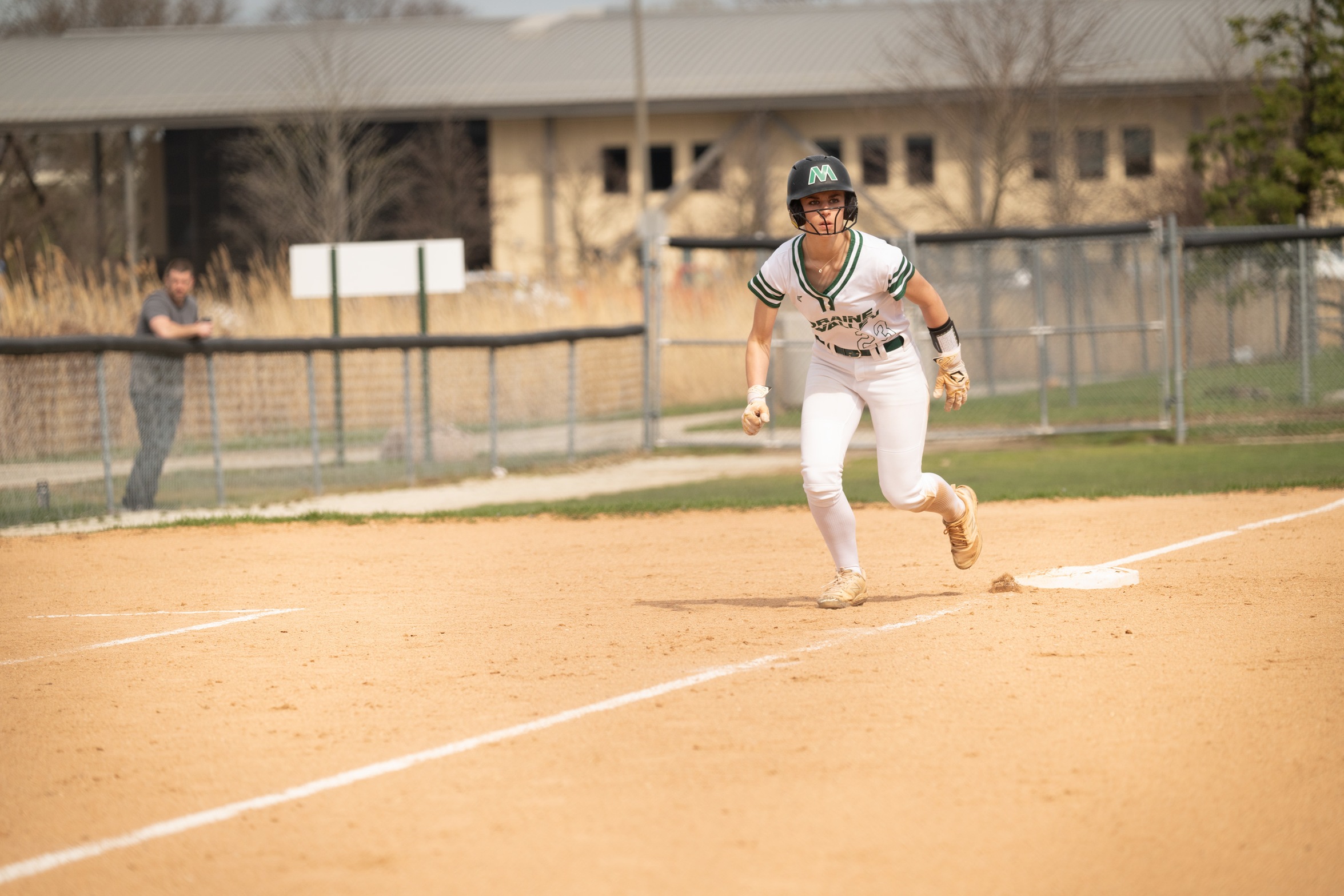 A softball player running from third base.